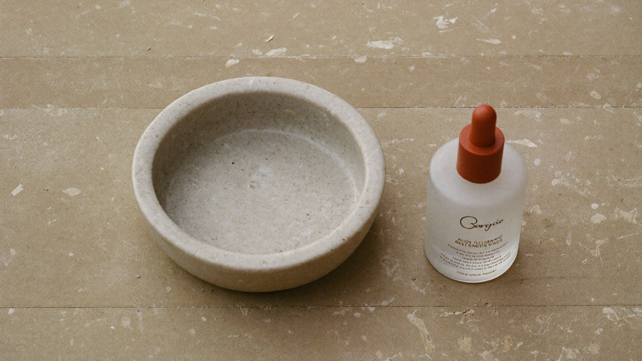 A calm, minimal still life of a matte ceramic dish on a soft neutral surface